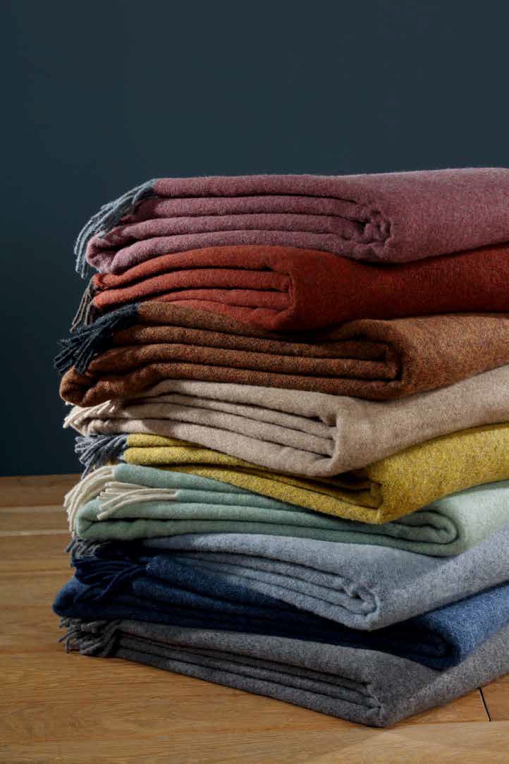 Пледы Biederlack CASHMERE сложены стопкой — виден весь ряд расцветок коллекции, включая оливковую (oliv loden)